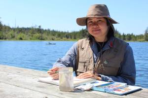 Photo by Karina Andrew/Whidbey News-Times
Nina Vichayapai shows her watercolor painting of the story pole at the Rosario Beach trailhead.
