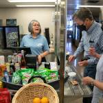 Maria Rios, a ferry worker of 13 years, helps Frank and Fran Butler, both of Washington, D.C., check out as the couple purchases food on Thursday, July 21, 2022, aboard the MV Suquamish ferry between Mukilteo and Clinton, Washington. Rios said food service returned to the Suquamish about three weeks prior. (Ryan Berry / The Herald)