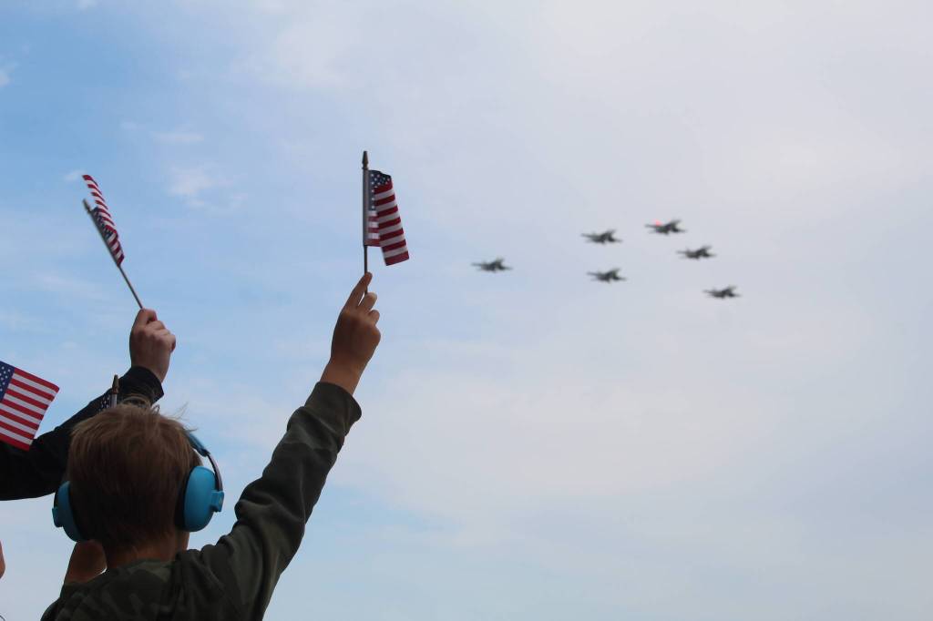 Family and friends of returning aircrews wave as jets bearing their loved ones home fly overhead. (Photo by Karina Andrew/Whidbey News-Times)