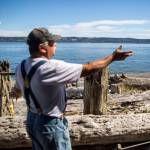 A fisherman puts fresh bait on his hook while Dan Cooper talks about fishing restrictions. (Olivia Vanni / The Herald)
