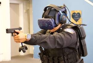 Photo by Rachel Rosen/Whidbey News-Times
Officer Shantel Ricci experiences a training scenario in the virtual reality world. She wears a headset connected to a backpack and carries a fake firearm.