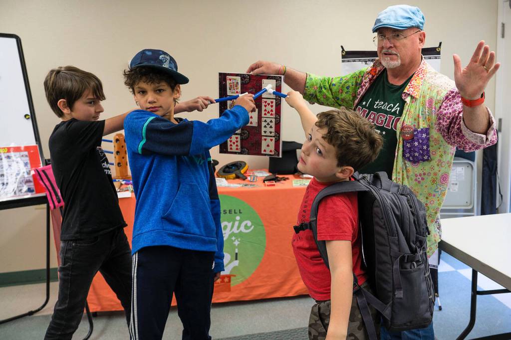From left to right, Cam Peloetier, 10, Miles Guggenheim, 9, and Dylan Gluckman-Oskin, 7, point to a card on the board that was chosen.