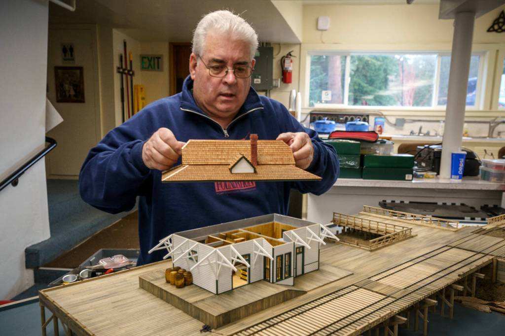 Photo by David Welton
Alan Murray places the roof on his replica of the Olympia train station.