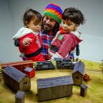 Photo by David Welton
Christian Gonzalez with Raphael, 2, and Zeke, 3, watch a model train in action.