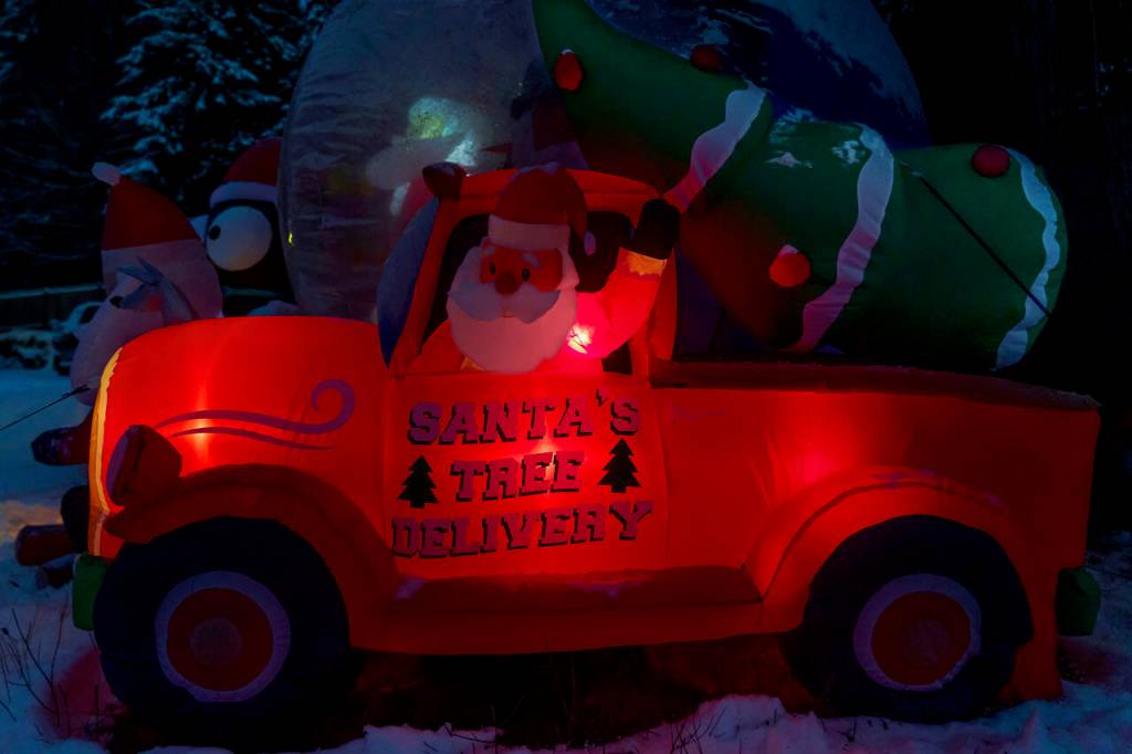 An inflatable Santa Claus makes a Christmas tree delivery. (Photo by David Welton)