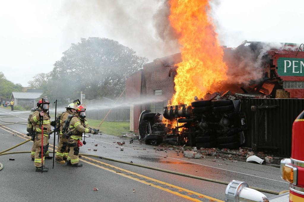 North Whidbey Fire and Rescue firefighters battle a blaze at Penn Cove Pottery after a semi truck crashed into the historic building in June. (Photo by John Fisken)