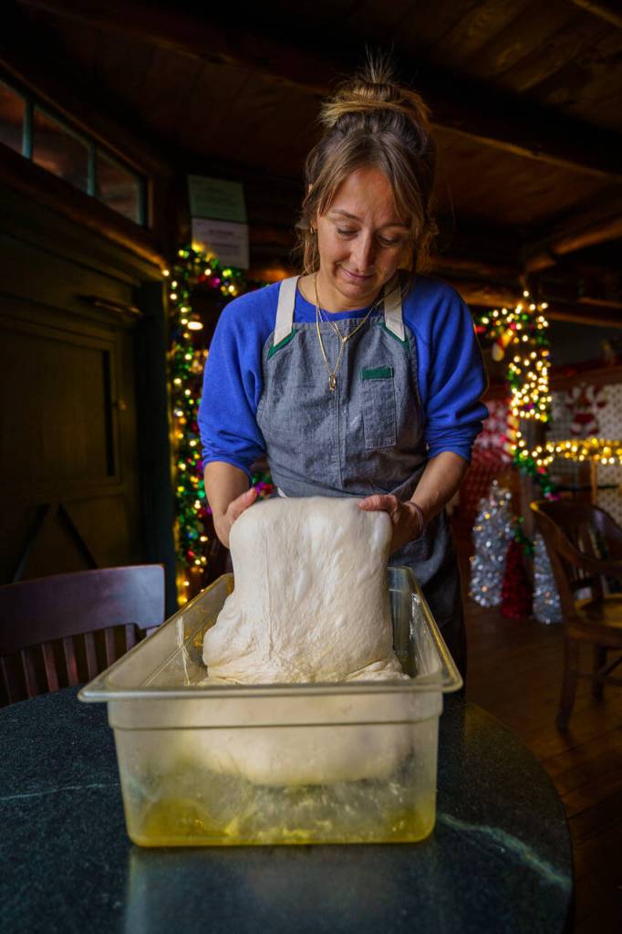 Courtney Storer flips focaccia dough. (Photo by David Welton)