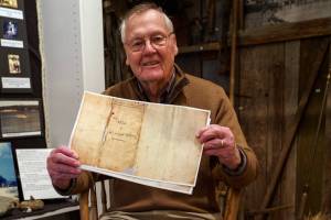 Photo by David Welton
South Whidbey Historical Society President William Haroldson proudly holds a paper copy of Whidbeys will. He has been studying Whidbeys life for the past 20 years, and even brought back a reprint of a portrait of the naval explorer from England in 2003.
