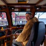 Photo by David Welton
Christopher Lewman takes the wheel of the Glacier Spirit for mussel raft tours during the Penn Cove Musselfest Sunday. The annual event, which was back at full strength, drew big crowds in Coupeville.