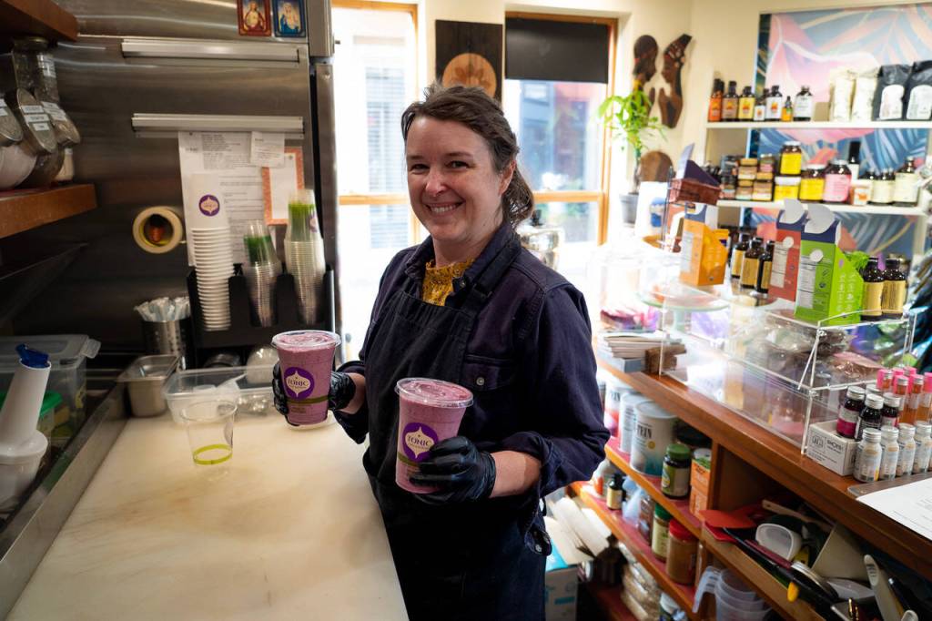 Employee Jennifer Adcock prepares two drinks.