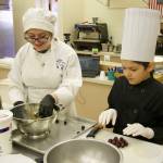 Kodi Ruiz (right) prepares grapes for a fruit salad. High school student Lily Erwin assists. (Photo by Rachel Rosen/Whidbey News-Times)