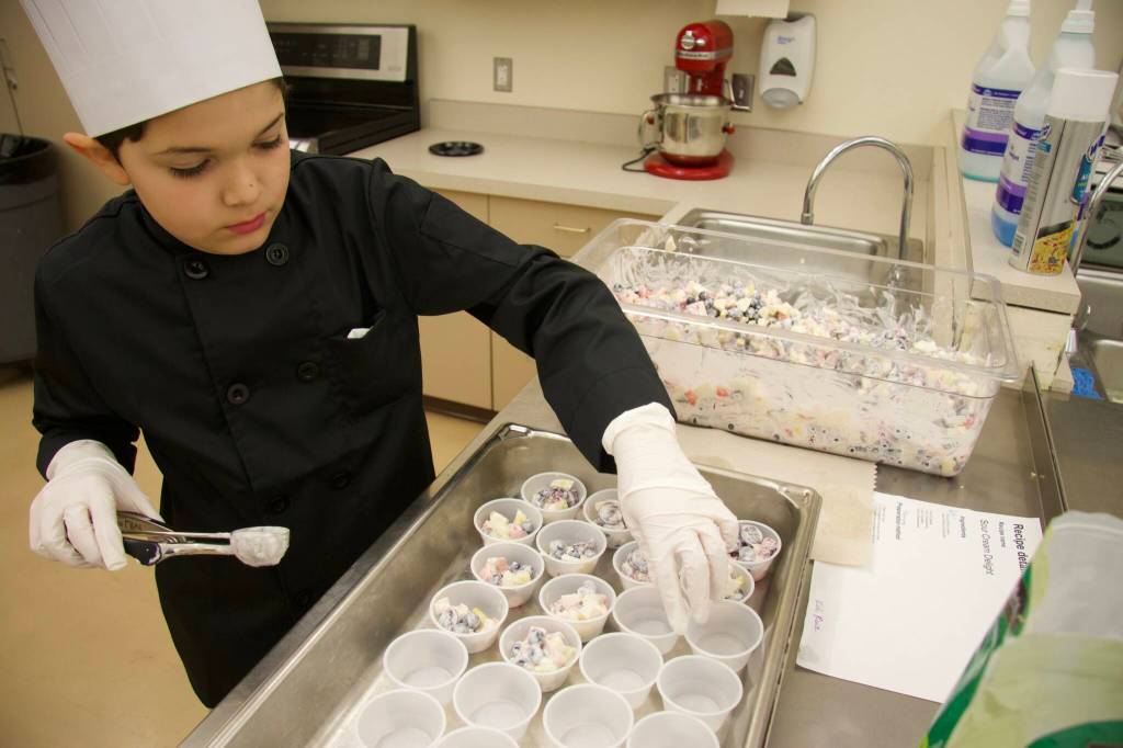 Oak Harbor Intermediate School student Kodi Ruiz prepares Sour Cream Delight, a fruit salad with sour cream and Stevia. (Photo by Rachel Rosen/Whidbey News-Times)