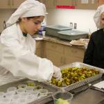 High school student Elizabeth Brennan (right) assist Madilyn Jones in preparing her Brussels sprouts dish. (Photo by Rachel Rosen/Whidbey News-Times)