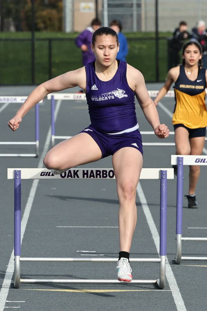 Bri Richard clears a hurdle at a March 19 track meet against Burlington. The Oak Harbor High School varsity girls team won 96.83 to 53.16. (Photo by John Fisken)