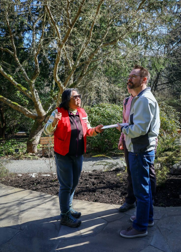 Docents Maria Cablao greets visitors in the gardens. (Photo by Cynthia Woerner)