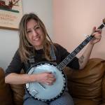 Gabbi Korrow practices playing the banjo in her living room. (Photo by David Welton)