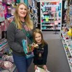 From left, Kayla and Avery Etheridge shop for dinosaur-themed birthday goodies at Whidbey Party Store. (Photo by Rachel Rosen/Whidbey News-Times)