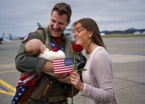 Photo by David Welton
Scott Waitley greets his wife, Maggie, and 2-month-old son, Warren, after returning home from deployment Saturday.