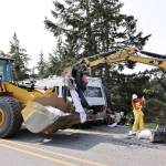 Island County employees clean up garbage from the sides of Hoffman Road. (Photo by John Fisken)