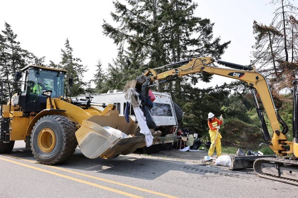 Island County employees clean up garbage from the sides of Hoffman Road. (Photo by John Fisken)