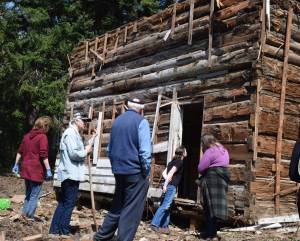 Photo by Patricia Guthrie
Marian Myszkowski, far left, looks over the cabin found hidden in the walls of an old farmhouse on her Langley property. Joining her are South Whidbey Historical Society members and students from Woodhaven School.