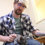 WAIF community outreach coordinator Tré Frampton plays with a kitten, one of many that has come through the shelter this year. (Photo by Karina Andrew/Whidbey News-Times)