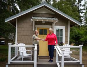 Photos by David Welton
Bon Thayer, THiNC site manager, and Deborah Hedlund, a member of the organizations board, shake hands at the completion of the tiny house project.