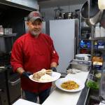 Photo by David Welton
Chef Chris Balora with dishes of kalua pig and Spam fried noodles.