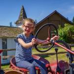 Second grader London Connell practices driving a toy tractor at the M-Bar-C Ranch. (Photo by David Welton)