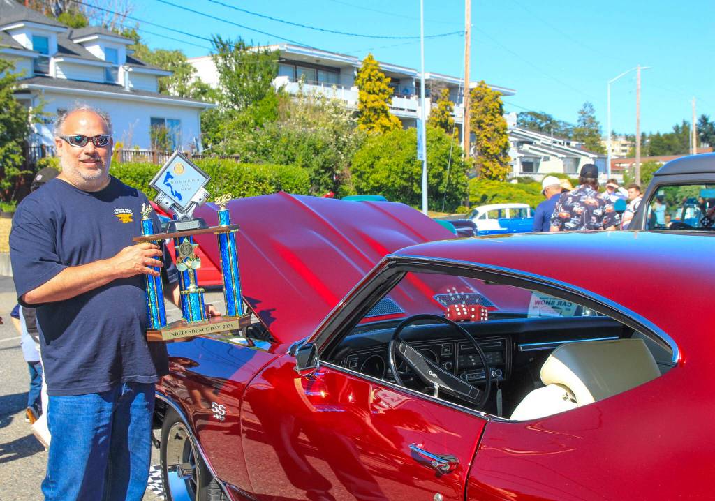 Bill Bennett holds his #1 trophy next to his 1969 Chevrolet Chevelle Super Sport, which he worked on for 20 years. (Photo by Luisa Loi)
