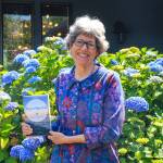 Photo by Luisa Loi
Barbara Wolf Terao holds her memoir, Reconfigured, in front of her house in Freeland.