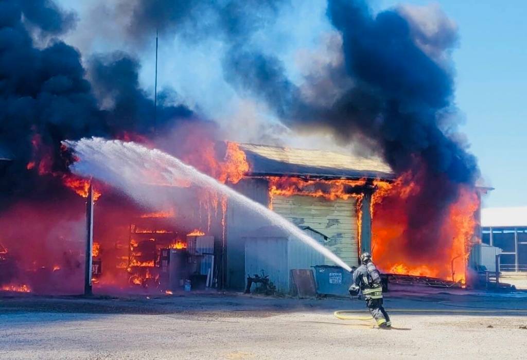 A Central Whidbey Island Fire and Rescue firefighter helps battle the blaze. (Photo by Chris Geiger)