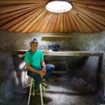 Eli Adadow sits inside one of his newer yurts, which will have a loft bed. (Photo by David Welton)