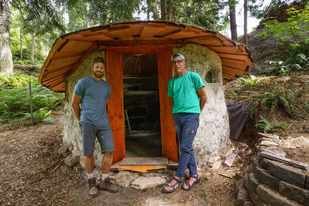 Apprentice Matthew Stalcup, left, and Eli Adadow stand outside a new yurt sanctuary that is under construction. (Photo by David Welton)