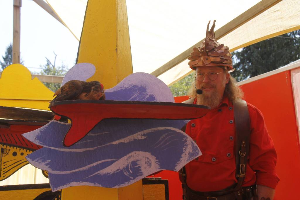 Ostrich the chicken, shown by 8-year-old Valerie Craven, surfs during the Clucky Show on Thursday with the help of Matt Hoar. (Photo by Kira Erickson/South Whidbey Record)