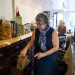 Karyn Schwartz pulls some herbs from an antique set of drawers within her apothecary. (Photo by David Welton)