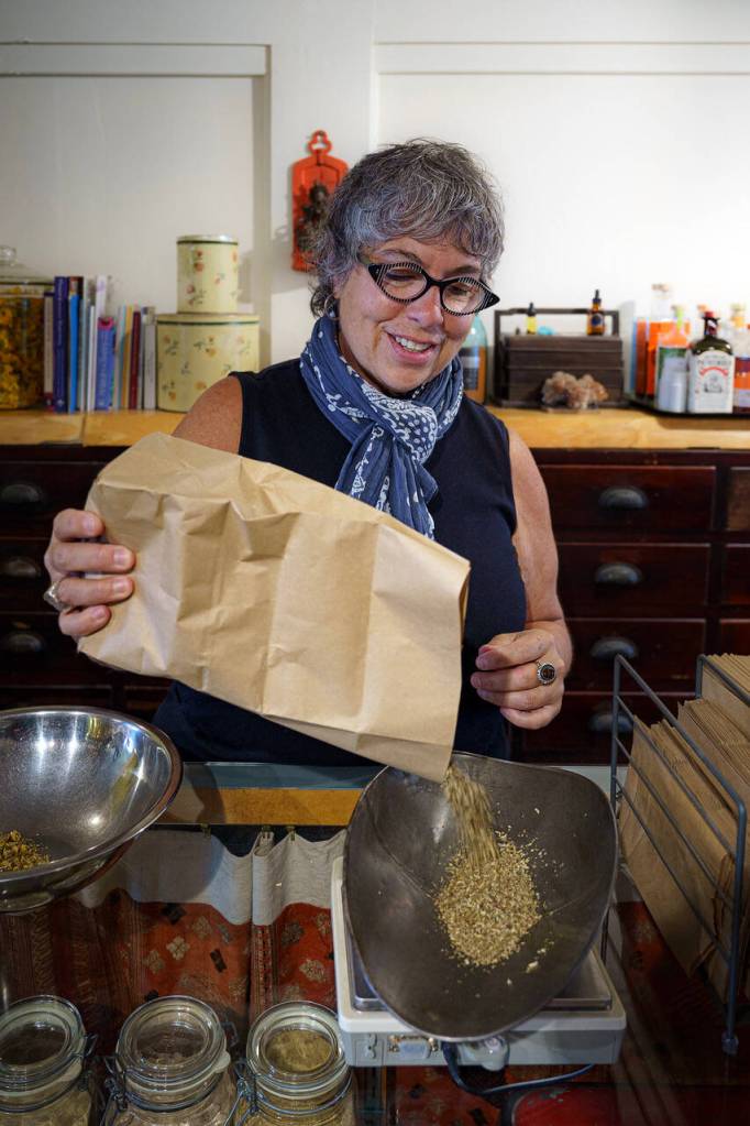 Karyn Schwartz measures out some herbs for a remedy. (Photo by David Welton)