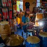 Keegan Harshman, organizer of Little BIG Fest, practices drums inside his Langley music store, Blue Sound Music. (Photo by David Welton)