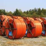 These orange rolled pipes, located at the Whidbey Telecom construction staging area in Langley, are conduits containing smaller tubes through which the fibers are pulled. They will be buried underground, on land. (Photo by Luisa Loi/Whidbey News-Times)