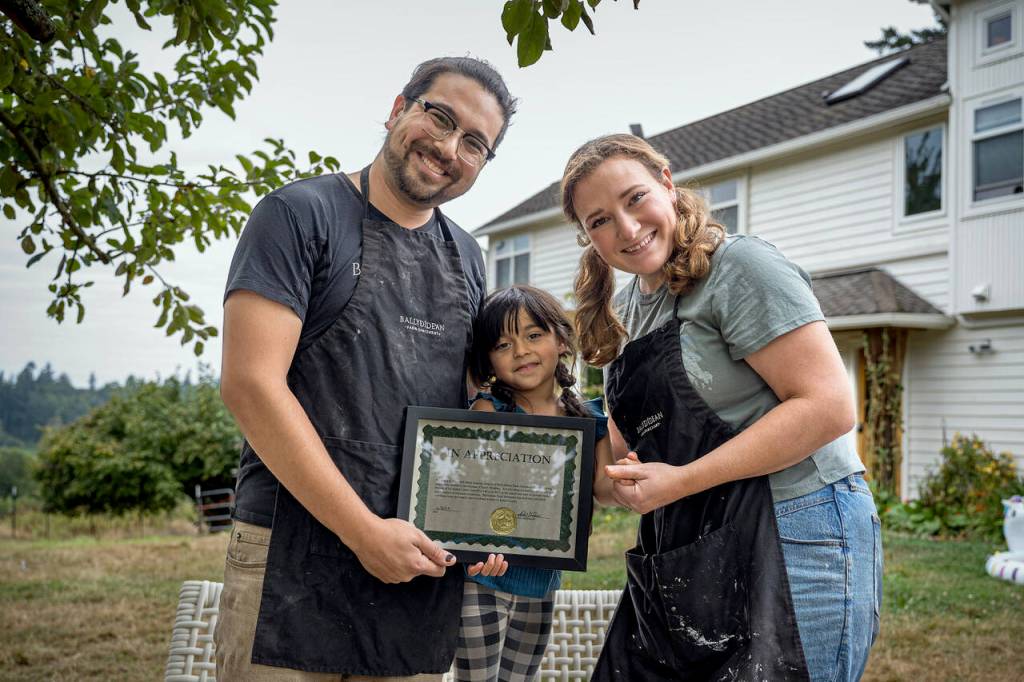 Photo by David Welton
From left, Ansel, Gwen and Sarah Santosa hold the award presented to Ballydidean Farm Sanctuary by the Island County Sheriffs Office.