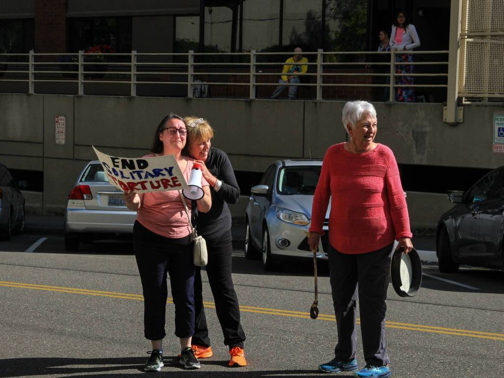 Photo by Luisa Loi/Whidbey News-Times
Patrice Huth embraces Christina Heins, whose son is among the around 50 individuals in max housing at the jail, as Dallas Huth takes a break from playing the tambourine.