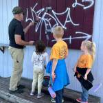 Scouts watch as theyre being shown how to paint a wall. (Photo provided)