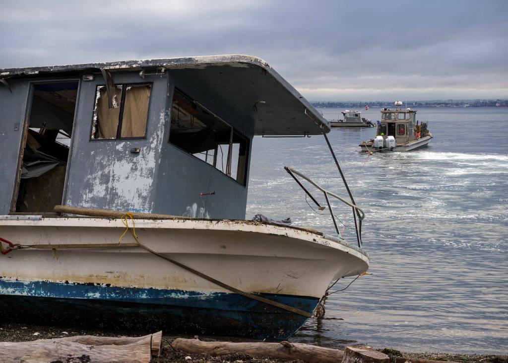 Photo by David Welton
On Tuesday morning, an abandoned boat was towed from the Clinton shore.