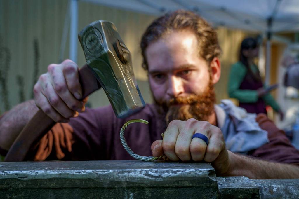 Marshall Suttles of the Burlington-based Suttles Knife and Sword business works on a torque to fit a mans wrist.