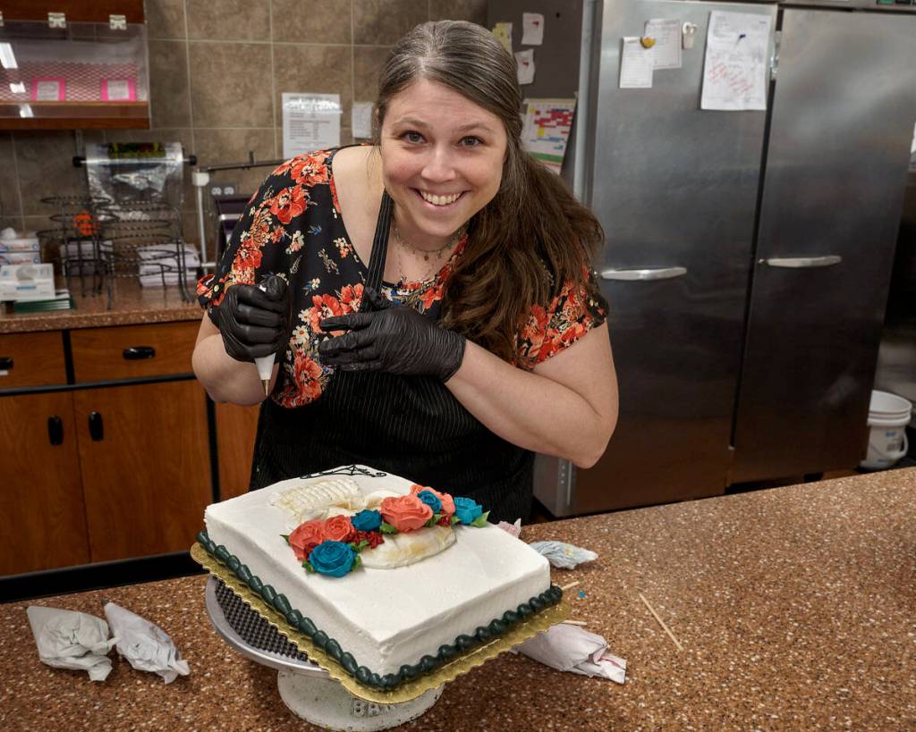 Photo by David Welton
Jennifer Holmes pipes a colorful flower crown for the La Catrina skull on her cake that has a Dia De Los Muertos theme.