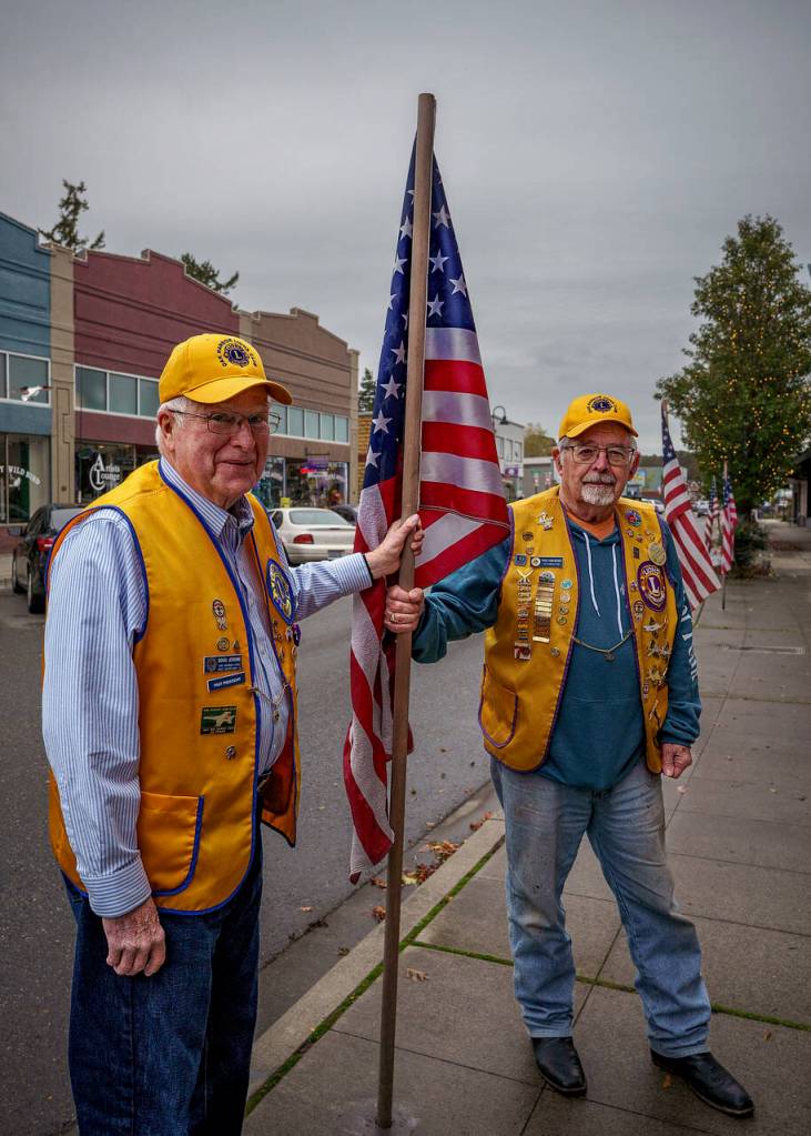 Tom Bond and Doug Jerome install a flag. (Photo by David Welton)