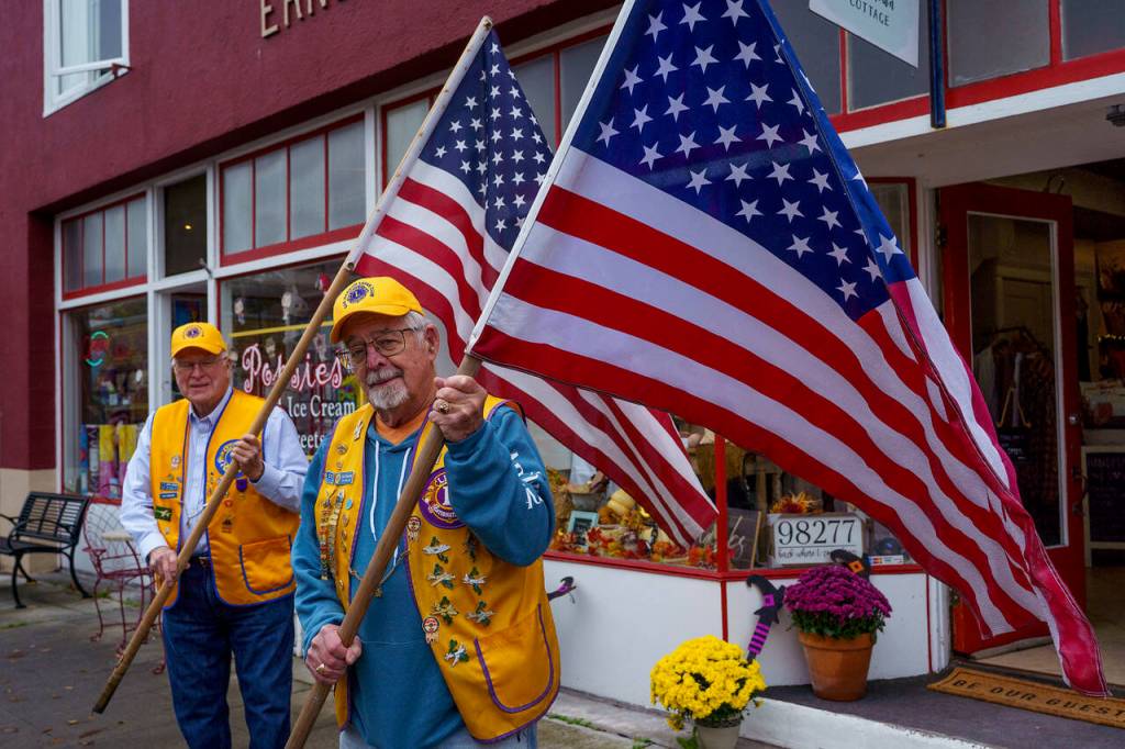 Doug Jerome and Tom Bond are among the Oak Harbor Lions Club members in charge of placing flags around Oak Harbor. (Photo by David Welton)