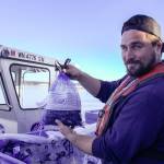 Zane Malloy proudly holds a bag of mussels. (Photo by Luisa Loi)