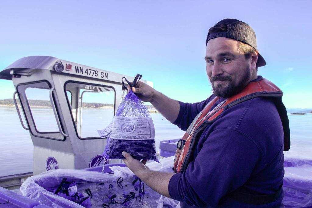 Zane Malloy proudly holds a bag of mussels. (Photo by Luisa Loi)