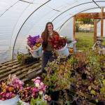 Emily Martin carries buckets of dried flowers into her hoop house. (Photo by David Welton)